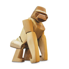 A wooden gorilla toy stands proudly on stout rear legs and powerful front arms.