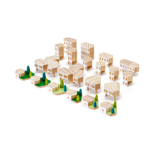 Wooden city blocks are arranged so that each individual block stands alone and is visible. The wooden blocks are painted white and look like building facades.