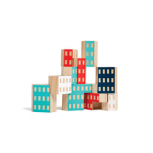wooden blocks are stacked like a building. The blocks have implied windows, and their hexagonal shape allows them to interlock when stacked.
