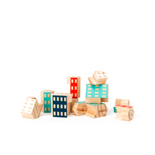 A pile of six sided wooden blocks. The pile is jumbled, with a few blocks stacked atop one another.