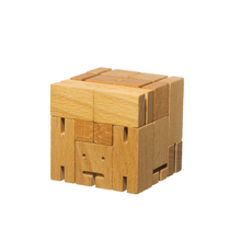 Toy wooden robot is folded into a perfect cube. The robot toy is a simple puzzle that can be unfolded into a standing robot.